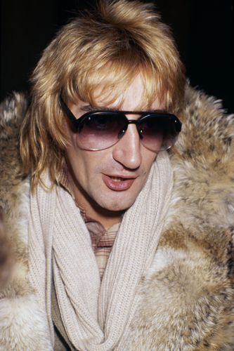 British singer Rod Stewart in fur coat and sunglasses