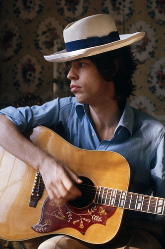 Mick Jagger of the Rolling Stones playing an acoustic guitar
